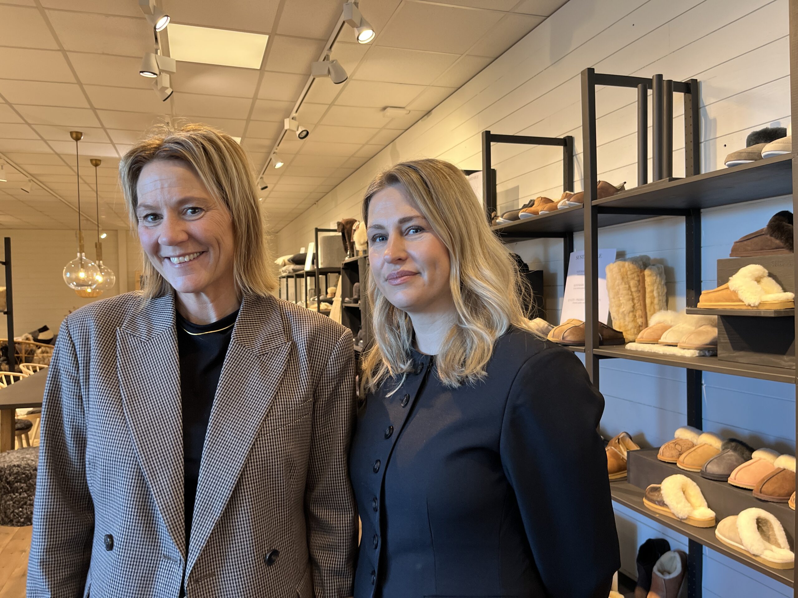 Bild på Linda Broman och Maria Leijonhufvud i butiken framför en hylla med skor